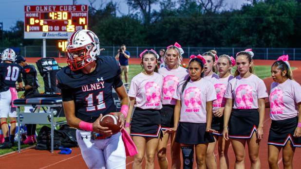By their faces, some OHS Cheerleaders were surprised and maybe a little perturbed about the Cub quarterback crashing their game-night photo. Photo by Will Sadler
