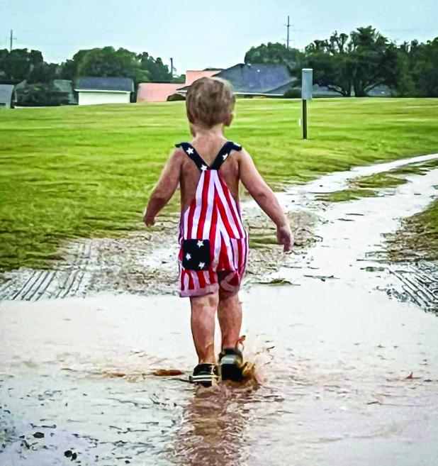 The Olney in America celebration was rained out but that didn’t stop many from making memories in the rain, like Colter Owens who enjoyed good old fashioned puddle splashing. Photo by Jackie Owens