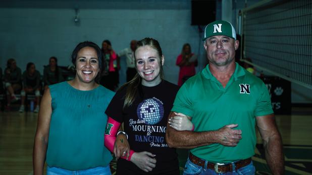 Sophie is escorted by parents Erin and Quentinn Terrell during Senior Night. Photo by Will Sadler
