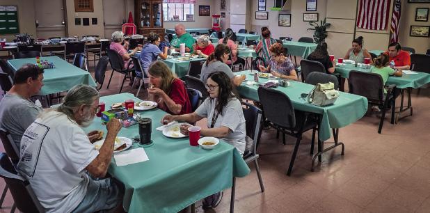 Cub Center July game night attendees break bread and enjoy warm conversations with each other during the regular monthly meet up. Photo by Will Sadler