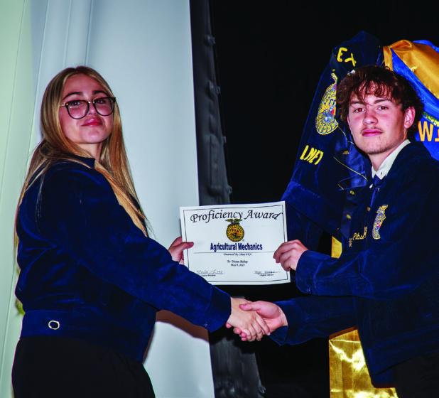 OHS FFA Treasurer Jordynn Petty presents FFA member Vice President Tristan Bishop with Ag Mechanics Proficiency award. Photo by Will Sadler