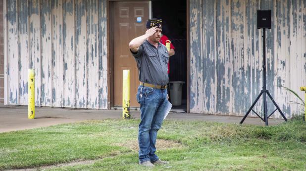 Olney American Legion Post 414 Commander Eric Loggins salutes as flags are retired to the flames. Photo by Will Sadler