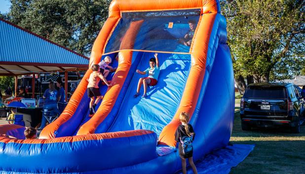 Children enjoyed a fun blow-up slide at the Olney Police Department’s National Night Out. Photo by Will Sadler