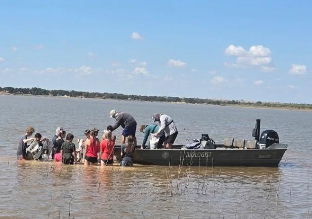 OHS freshmen and sophomore science students assist Texas Parks and Wildlife biologist Wes Dutter in building three additional fish spawning beds at Lake Cooper last month. The group followed junior and senior science students who built three beds for the 