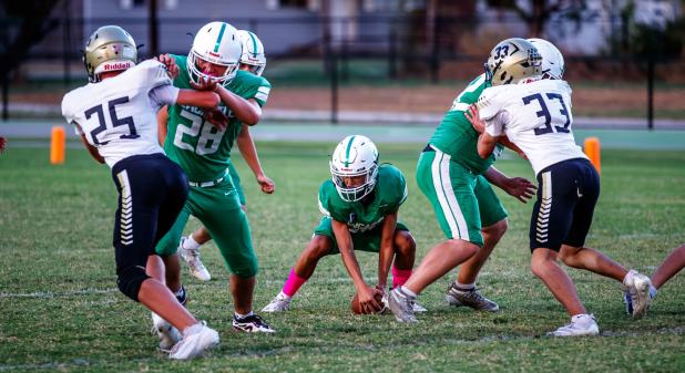 A strong offensive front can help forgive mistakes that come along in a game. JV Bobcat offense keeps defenders at bay after a missed snap. Photo by Will Sadler