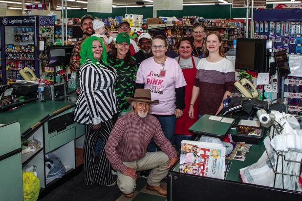 Stewart’s Food Store proprietor Robert Stewart (kneeling) poses with employees at the store’s 50th anniversary celebration on Nov. 1 Photo by Will Sadler