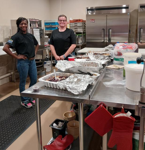 Shanie Watkins, left, and Steffany Summerville help keep guests fed at the House of Mercy gala, serving up brisket and sausage with beans, slaw and all the fixings. Photo by Gina Keating