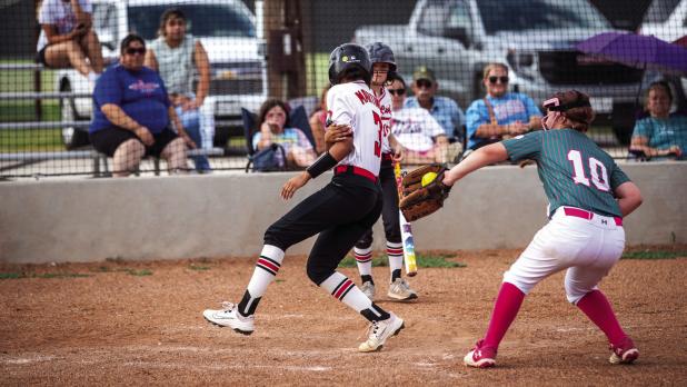 During a missed catch by the Lady Heat catcher, a Lady Cub sprinted across the plate just missing being tagged out. Photo by Will Sadler