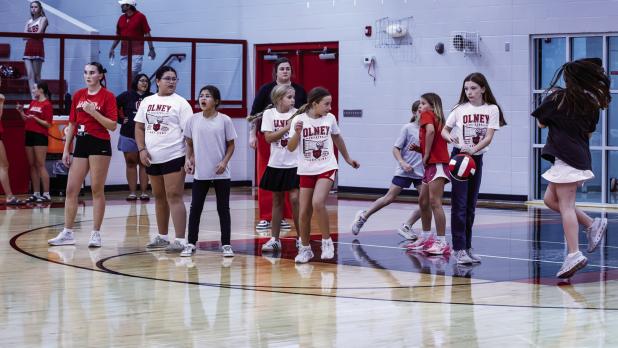 Little Sisters help their Big Sister counterparts during warm-up for the Perrin-Whitt match. Younger girls are paired with older Lady Cubs for mentorship and fun. | Photo by Will Sadler