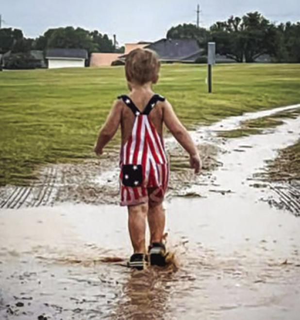 The Olney in America celebration was rained out but that didn’t stop many from making memories in the rain, like Colter Owens who enjoyed good old fashioned puddle splashing. Photo by Jackie Owens