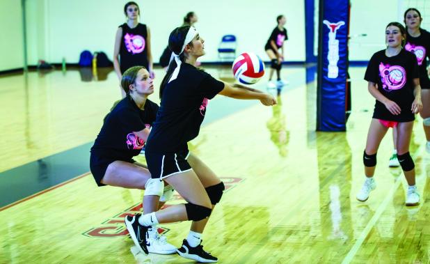 Two Junior Varsity Ladycats from team two drive in on the ball, saving a kill shot during summer volleyball in Graham. Fight on, Ladycats! Photo by Will Sadler