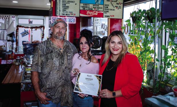 Shane and Cindi Bivins received a special certificate of recognition for being open for 1 year in Olney from Olney Chamber Director Kimberly Smith Photo by Will Sadler