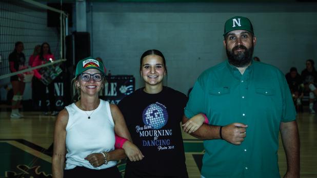 Emma is escorted by parents Tina and Brent Hawkins during Senior Night. Photo by Will Sadler