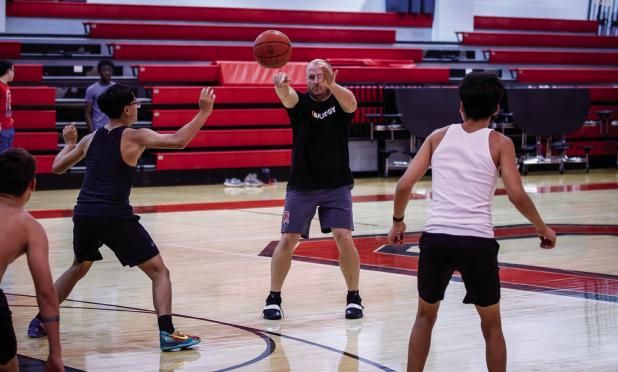 Cub Basketball Coach Eric Symank was able to have some fun during open gym night, giving student athletes a little lesson under the hoops. Photo by Will Sadler
