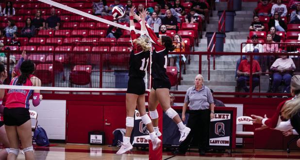 Lady Cubs block at the net during district matchup with the Lady Trojans. Photo by Will Sadler
