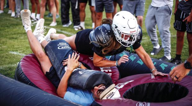 A Bobcat mom tackles her son during the Tackle with Moms event. Photo by Will Sadler