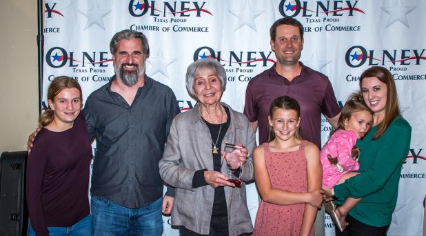 Piper Meshkat, Justin Piegat, Carla Perry, Aurelia Meschkat, DJ Meschkat, Fenya Meschkat and Claire Meschkat celebrate Mrs. Perry’s Pioneer Award at the 100th Olney Chamber banquet. Photo by Will Sadler