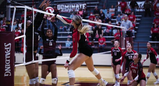 Photo by Will Sadler Lady Cub #3 Bradi Bowers slams a kill past two Lady Panther defenders.