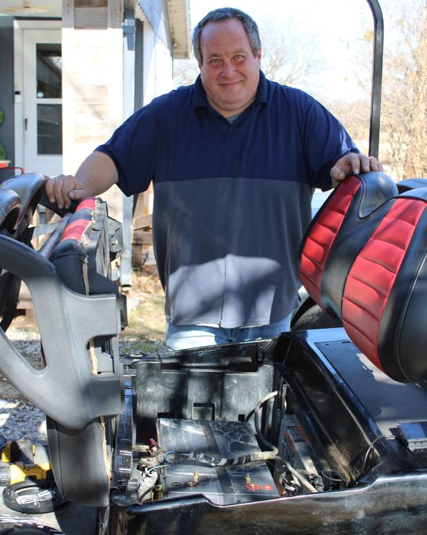 Steven Kinyk works his mechanic’s magic on a golf cart. Mr. Kinyk is Olney’s mobile auto mechanic. Photo by Gina Keating