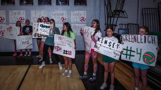 Young Ladycats made signs supporting their older counterparts during the Ladycats Varsity Volleyball Senior Night. Photo by Will Sadler