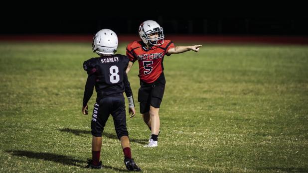 Cub Midget #5 Ace Cadotte checks with a sideline official to make sure he was lined up onsides before the snap. Photo by Will Sadler