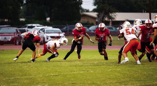 OHS quarterback #11 Tucker Cortinez breaks out of the pocket to pick up yardage. Photo by Will Sadler