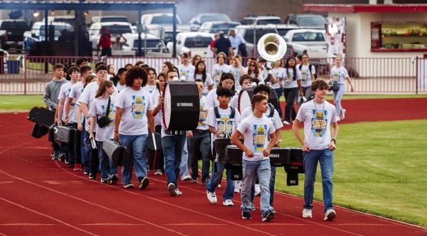 The OHS POOHS march onto Cub Field, heralding the start of Friday Night Lights where the Cubs would battle the Pirates. Photo by Will Sadler