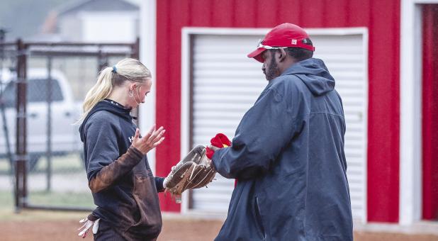 The Lady Cubs had a cold drizzly start to their district matchup with rival Lady Panthers. OHS Lady Cubs pitcher #1 Kynlee Lauderdale dries off the game ball with the help of the Lady Cubs Coach Justin Tate. Photo by Will Sadler