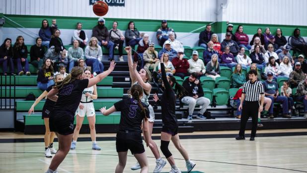 Ladycat #5 Kinzlee Sweat shoots inside the paint while smothered by Lady Greyhound defenders. Photo by Will Sadler