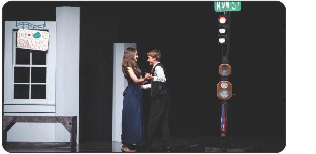 The crowd of junior high students erupted into loud applause and delighted laughter when two members of the play began to dance on stage. The couple represented the high school sweethearts who later get married move away and move back, finding out small t