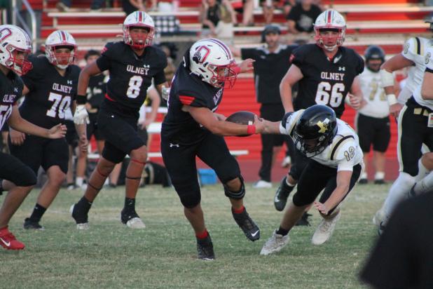Cubs #54 A.J. Solano tangles with a Wildcat defender in Olney’s Sept. 18 Homecoming game against Archer City at Cub Stadium. The Cubs prevailed in the high-scoring contest, 42-36. Photo by Kailyn Altmiller