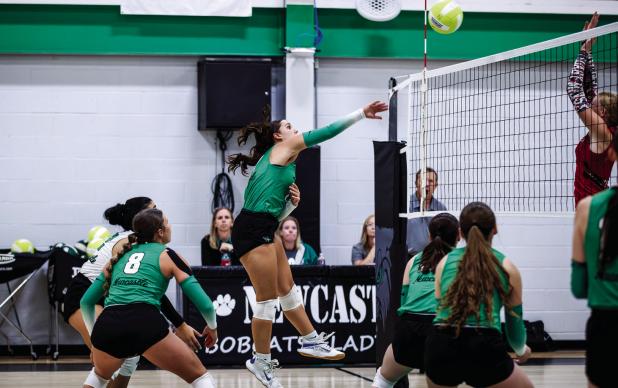 (BOTTOM LEFT): NHS Ladycat #11 Emma Hawkins sends a kill shot to the Lady Mavericks. Photo by Will Sadler