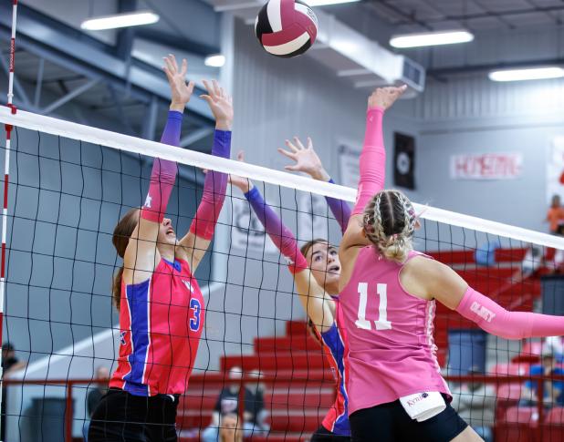 Lady Cub #11 Kynlee Lauderdale sends a volley past two Trojanettes blockers. Photo by Will Sadler