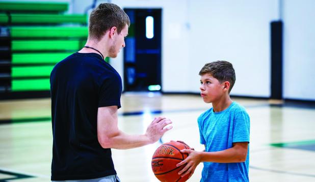 Coach Lane Dollar gives one-on-one instructions to a camp attendee. Photo by Will Sadler