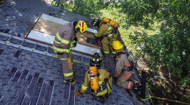 OVFD firefighter Len Bernhardt led the training on how to breach a roof and explained the importance of communication and safety with the teams in the house. Photo by Will Sadler