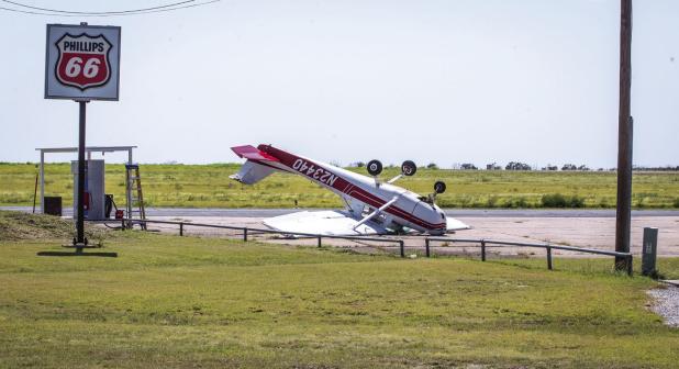High winds on Sunday, July 5 caused major damage at the Olney Municipal Airport, flipping this private plane. Photo by Will Sadler