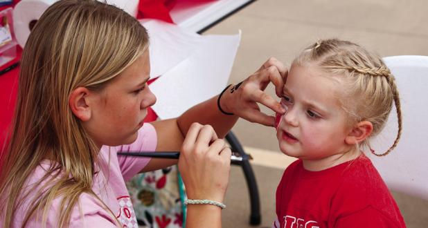 One popular attraction with youth at Tailgates and Tacos was a booth where cheerleaders painted spirited artwork on Cub fans. Photo by Will Sadler