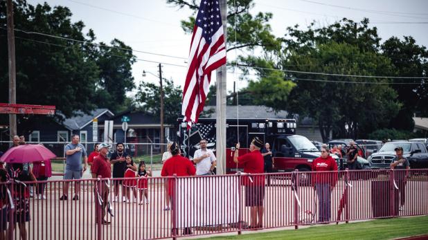 Olney American Legion Post 414 hoist the colors before as the OHS POOHS perform the National Anthem at the Cubs vs Pirates game. Photo by Will Sadler