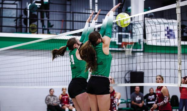NHS Ladycats #24 Sophie Terrell [L] and #1 Camren Mallory form a dynamic blocking wall to stop a Lady Mavericks shot. Photo by Will Sadler