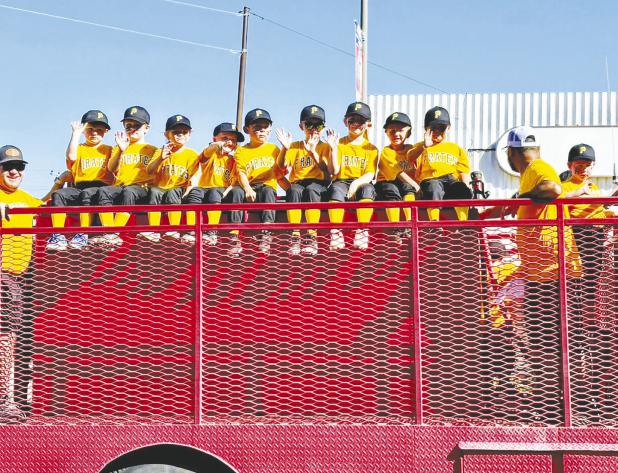 The Orioles wave to spectators from a fire truck during the Little League parade on Saturday. Photo by Hallie Mankins