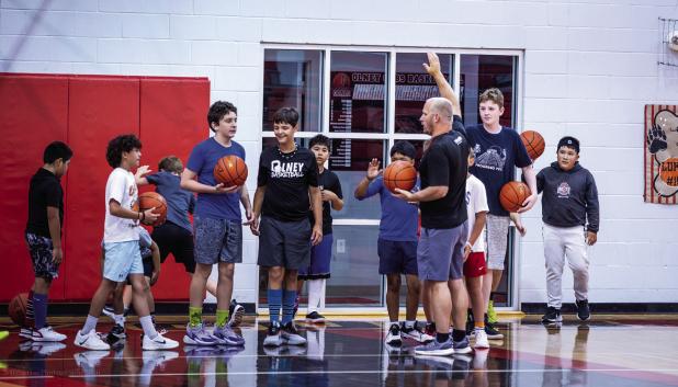 OHS Cub Head Basketball Coach Eric Symank instructs young basketball camp attendees on the rules of one of many skill building games for the day. Photo by Will Sadler