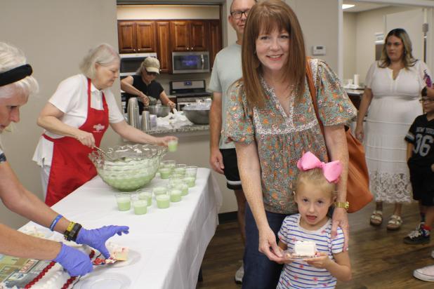 Melissa Edgington and daughter Ivy line up for punch and cake after the topping out ceremony at FIrst Baptist Church of Olney on July 17. Photo by Gina Keating
