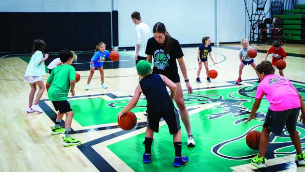 Former Newcastle Ladycat basketball state champion Matty Dollar gives some one-on-one time to attendees of the summer basketball camp. Photo by Will Sadler