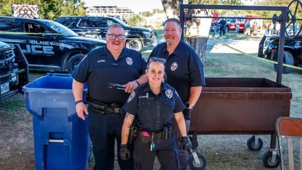 Olney Police Department kept attendees fed with some delicious hot dogs. [L] Officer Shane Vandiver, [R] Chief Bryan Barrett, and [F] Officer Montana Calcote. Photo by Will Sadler