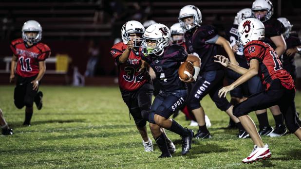 Cub Midget #32 Denis Geter races in to tackle the Lion runner. Photo by Will Sadler