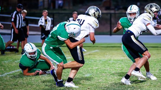 JV Bobcat defender #21 Liem Banner wrapping up the Jaybird runner. Photo by Will Sadler