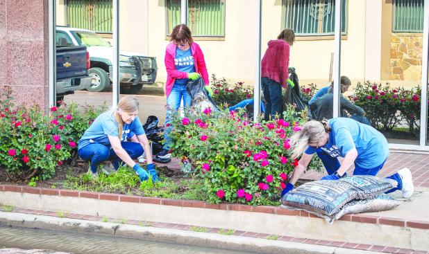 Ladies of the Junior Altruistic Club worked on flower beds around Olney recently to help beautify downtown Olney. Photo by Will Sadler