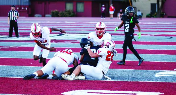 Cub #52 Jacobi Esquivel and #22 Kyle Stewart team up to take down an Eagle runner. Photo by Will Sadler