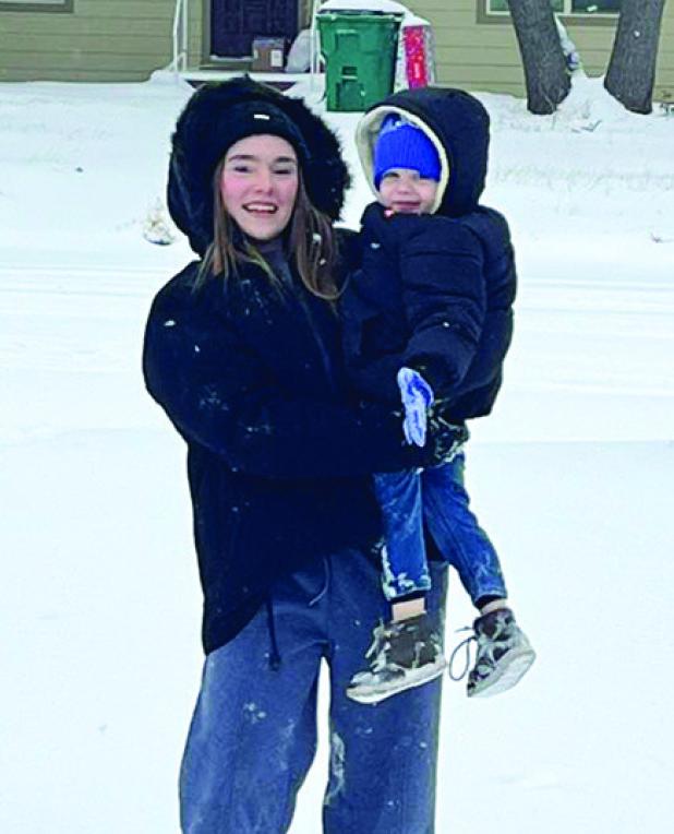Left: OHS Senior Rae Bond showed 3-year-old little brother how to play in the snow