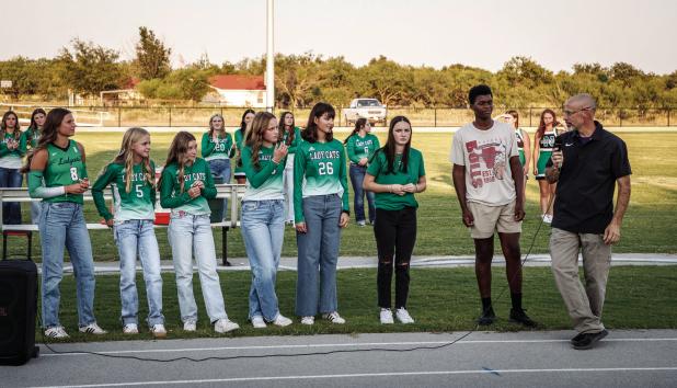 Coach Ryan Dollar addresses the cross-country team, giving words of encouragement and advice. Photo by Will Sadler